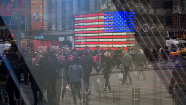 Pedestrians are reflected in a window of the Nasdaq MarketSite in the Times Square neighborhood of New York. 