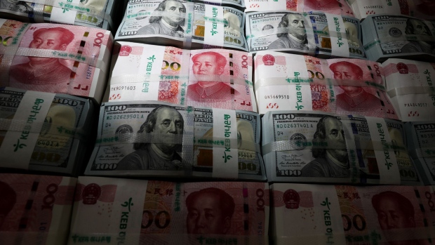 Genuine bundles of Chinese one-hundred yuan banknotes and U.S. one-hundred dollar banknotes are arranged for a photograph at the Counterfeit Notes Response Center of KEB Hana Bank in Seoul, South Korea, on Friday, July 13, 2017. Yuan is set to slide for fifth week, longest losing streak since July 2016, as escalating U.S.-China trade tensions weigh on sentiment. 