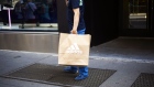 A shopper carries an Adidas AG retail bag in the SoHo neighborhood of New York, Aug. 12, 2018. 