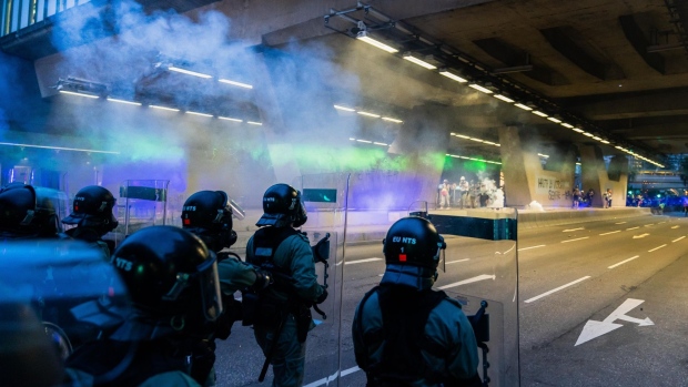Riot police fire teargas during a protest in Tai Wai on Aug. 10. Photographer: Billy H.C. Kwok/Getty Images