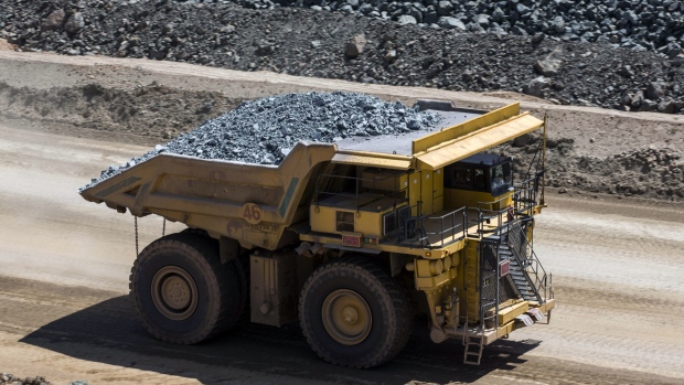 A dump truck operates in an open pit at copper-gold mine. 