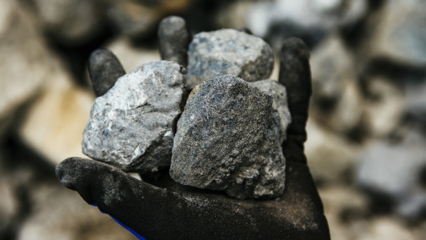 A worker holds rocks of raw platinum ore for a photograph at the Northam Platinum Ltd. Booysendal platinum mine, located outside the town of Lydenburg in Mpumalanga, South Africa, on Tuesday, Jan. 23, 2018. Booysendal will use a system developed by an Austrian company that builds ski lifts to transport the ore up a 30 degree incline out of a valley for processing, instead of the traditional conveyer used throughout South Africa or the more expensive option of trucking. 