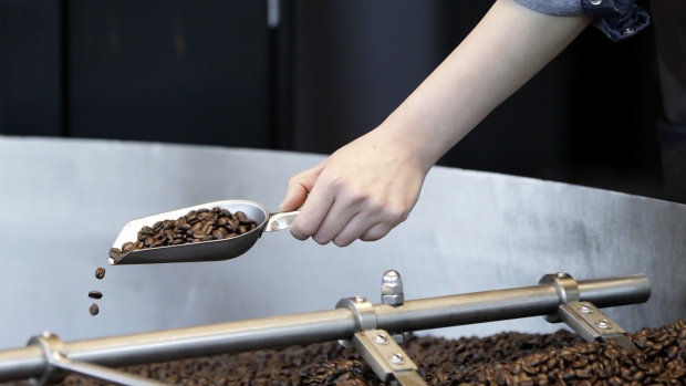 A Starbucks Corp. employee takes a scoop of coffee beans from a roaster during a media tour of the company's Reserve Roastery in Tokyo, Japan, on Wednesday, Feb. 27, 2019. Starbucks will open its high-end roastery store, the first in Japan and fifth in the world, on Feb. 28. 
