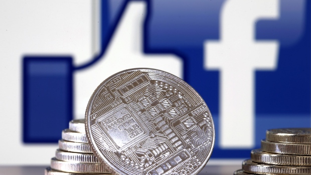 PARIS, FRANCE - JUNE 18: In this photo illustration, a visual representation of a digital cryptocurrency coin sits on display in front of a Facebook logo on June 17, 2019 in Paris, France. Facebook will announce Tuesday, June 18 the details of its cryptocurrency, called " Libra ". Like bitcoin, the best-known virtual currency, it will rely on blockchain technology. This universal currency must allow its users to buy products or services from the Facebook universe, which also owns Messenger, Instagram and WhatsApp. It will also be possible to transfer "Libras" between individuals. Several companies like Visa, MasterCard, PayPal and Uber have already joined the consortium created by Facebook. (Photo by Chesnot/Getty Images) 