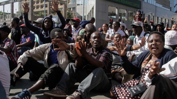Demonstrators sit and sing protest songs after police cordoned off the street in Harare, on Aug. 16. 