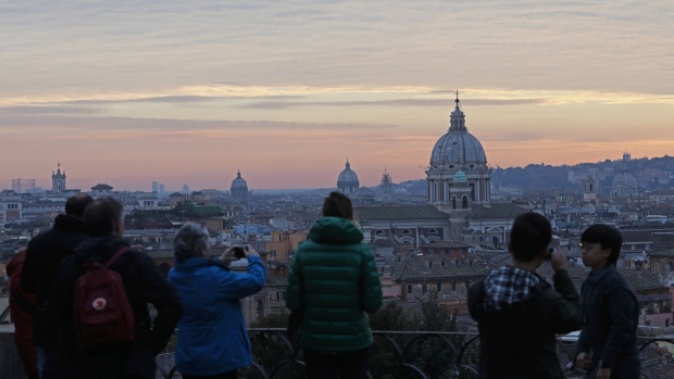Visitors take pictures of the city skyline at dusk in Rome, Italy, on Sunday, Dec. 4, 2016. Italians are voting on constitutional changes proposed by Italian Prime Matteo Renzi to limit the power of the Senate, the upper house of parliament. 