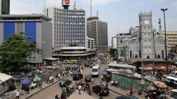 Pedestrians pass street traders in the business district of Lagos, Nigeria, on Monday, Oct. 26, 2015. 