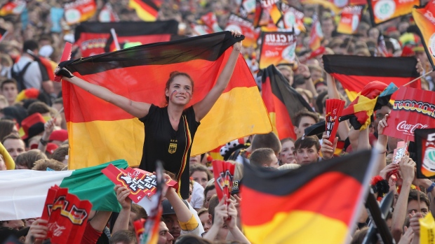 BERLIN, GERMANY - JUNE 28: Fans wave German flags at the Fanmeile public viewing at Brandenburg Gate prior to the Germany vs. Italy UEFA Euro 2012 semi-finals match on June 28, 2012 in Berlin, Germany. (Photo by Sean Gallup/Getty Images)