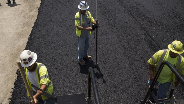 Contractors pave a road during highway construction between U.S. Route 23 and U.S. Route 52 near Portsmouth, Ohio, U.S., on July 26, 2017. The U.S. Census Bureau is scheduled to release construction spending figures on August 1. 