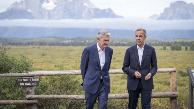 Jerome Powell, chairman of the U.S. Federal Reserve, left, and Mark Carney, governor of the Bank of England (BOE), walk the grounds during the Jackson Hole economic symposium, sponsored by the Federal Reserve Bank of Kansas City, in Moran, Wyoming, U.S., on Friday, Aug. 23, 2019. Powell said the U.S. economy is in a favorable place but faces "significant risks," reinforcing bets for another interest-rate cut next month though the remarks failed to mollify President Donald Trump. David Paul Morris/Bloomberg