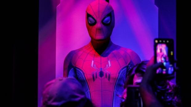 Attendees take pictures of a Spider-Man suit on display at the Marvel Studios Avengers Campus preview at the D23 Expo 2019 in Anaheim, California, U.S., on Friday, August 23, 2019. Walt Disney Co. is turning the D23 Expo, the biennial fan conclave, into a big push for its new streaming services. 