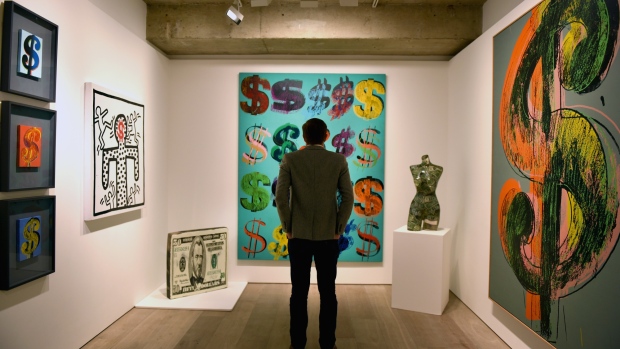 LONDON, ENGLAND - JUNE 08: A visitor studies 'Dollar Signs', 1981, by Andy Warhol which has an estimated value of £4.5-6.5 million and is going on show at Sotheby's on June 8, 2015 in London, England. The work is a centrepiece of an exhibition of 21 pieces inspired by the US Dollar which are estimated to have a total value of £50 million and will go under offer by the auction house on 1st and 2nd July 2015. (Photo by Mary Turner/Getty Images) 