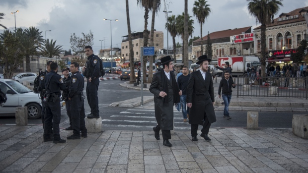 Two orthodox Jewish men walk past police officers near the Damascus Gate outside the Old City in Jerusalem, Israel, on Friday, Dec. 15, 2017. The United Nations Security Council is expected to vote on an Egyptian draft resolution Monday that "calls upon all States to refrain from the establishment of diplomatic missions" in Jerusalem, after U.S. President Donald Trump recognized the city as Israel’s capital. 
