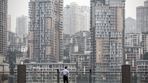 A man looks on from a viewing platform in front of residential buildings in Chongqing, China, on Tuesday, May 31, 2016.