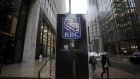 Pedestrians carry umbrellas while walking past Royal Bank of Canada (RBC) signage displayed at the Royal Bank Building during the company's annual general meeting in Toronto, Ontario, Canada, on Thursday, April 6, 2017. RBC Chief Executive Officer David urged lawmakers to coordinate interventions and act quickly to cool housing markets, particularly in Toronto and Vancouver. 