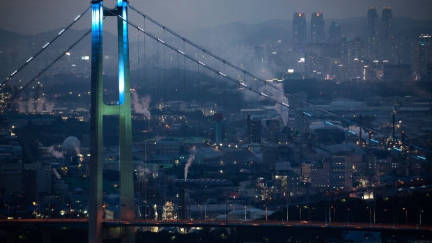 Smoke billows from an industrial complex beyond the Ulsan Harbor Bridge at night in Ulsan, South Korea, on Sunday, Aug. 4, 2019. Ulsan is known as Hyundai Town, an industrial powerhouse with the world’s largest car-assembly plant, its third-biggest oil refinery and the giant shipyards. Since 2016, some 35,000 workers quit or lost their jobs at the city's shipyard, in a downturn as dramatic as it was sudden. 