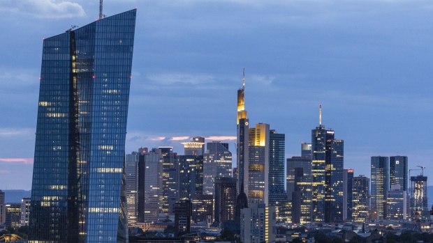 Skyscrapers including the headquarters of the European Central Bank (ECB), left, Commerzbank AG, center, and twin tower headquarters of Deutsche Bank AG, right, stand illuminated at dusk in the financial district in Frankfurt, Germany, on Tuesday, Aug. 13. 2019. 