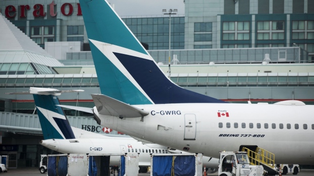 A Boeing Co. 737-800 WestJet Airlines plane sits at a gate at Toronto Pearson International Airport. 