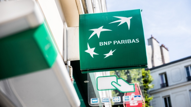 A BNP Paribas SA logo sits on a sign outside a BNP Paribas bank branch in Paris, France, on Tuesday, July 18, 2017. BNP Paribas agreed to pay $246 million to settle Federal Reserve allegations that the bank failed to keep its currency traders from using electronic chatrooms to manipulate prices. 