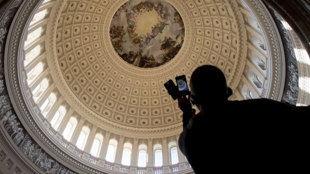 A visitor uses a mobile device to take a photograph of the U.S. Capitol Rotunda in Washington, D.C., U.S., on Thursday, Dec. 28, 2017. Profound differences between House and Senate Republicans may play as big a role as GOP fights with Democrats on how the legislative agenda plays out when Congress returns in January. 