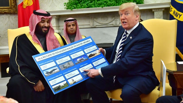 Mohammed bin Salman, Saudi Arabia's crown prince, left, smiles as U.S. President Donald Trump, holds a chart displaying military hardware sales during a meeting in the Oval Office of the White House in Washington, D.C., U.S., on Tuesday, March 20, 2018. The U.S. and Saudi Arabia are developing an increasingly close partnership, encompassing everything from isolating Iran to bolstering business ties beyond energy into technology, defense and entertainment. 