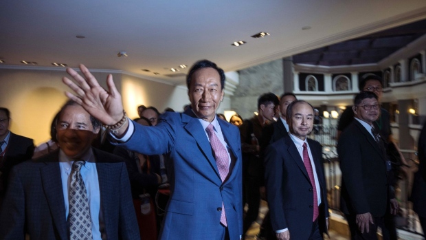 Terry Gou, former chairman of Foxconn Technology Group, center, waves as he walks with Michael Marks, chairman of Katerra Inc., left, and Masayoshi Son, chairman and chief executive officer of SoftBank Group Corp., during the G2 and Beyond Conference in Taipei, Taiwan, on Saturday, June 22, 2019. Gou, stepped down as Hon Hai chairman on June 21 to focus on winning a party nomination to compete in the 2020 Taiwanese presidential elections, had run a company that depends on Apple for half its revenue. Photographer: Billy H.C. Kwok/Bloomberg