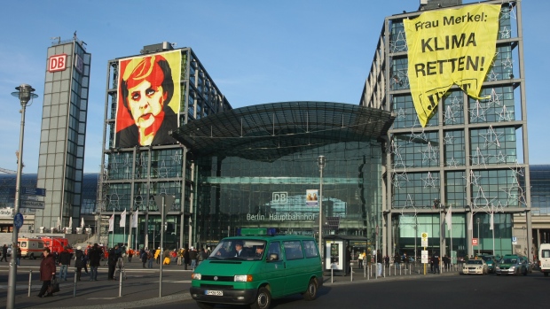BERLIN - DECEMBER 03: A police van drives past giant banners showing German Chancellor Angela Merkel that read: "Climate Protection Now! Copenhagen 2009" (L) and "Mrs. Merkel: Save the Climate! Now!" hanging from Hauptbahnhof train station on December 3, 2009 in Berlin, Germany. The banners, hung by Greenpeace activists, refers to the upcoming summit on climate change in Copenhagen, where Chancellor Merkel will lead the delegation representing Germany. (Photo by Sean Gallup/Getty Images)