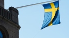 A national flag of Sweden hangs from a commercial building in Stockholm, Sweden. 