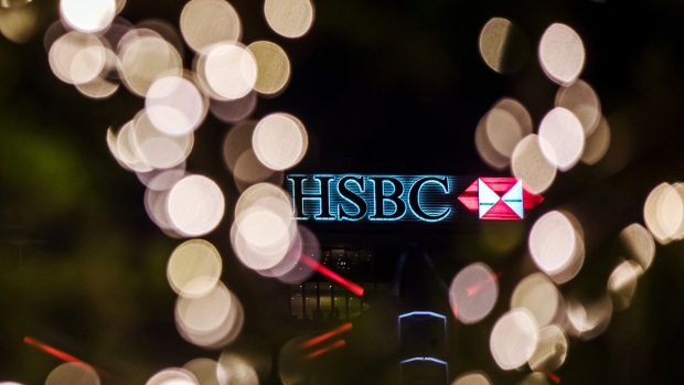 Signage is illuminated atop the HSBC Holdings Plc headquarters building at night in Hong Kong, China, on Thursday, July 25, 2019. HSBC is scheduled to release interim earnings results on Aug. 5. 