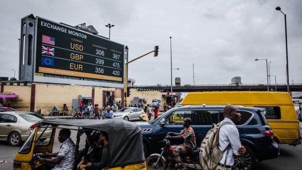 A taxi passes a giant advertising screen showing U.S. dollar, British pound and euro foreign currency exchange rates on a road in Lagos, Nigeria. 
