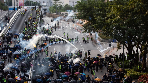 Demonstrators throw back tear gas canisters toward riot police during a protest in the Admiralty district of Hong Kong on Sept. 15, 2019. 