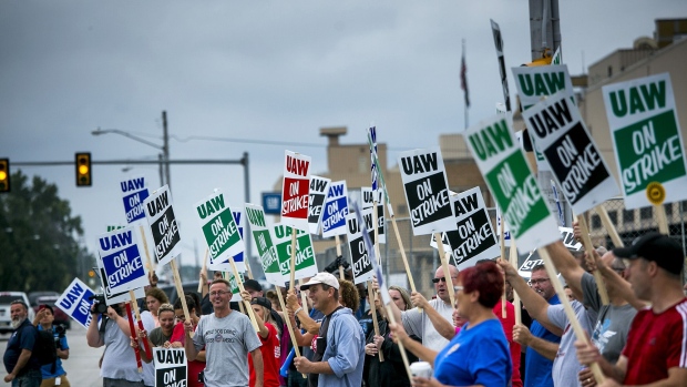 Demonstrators holds signs during a strike outside the GM assembly plant in Flint, Michigan on Sept. 16. 