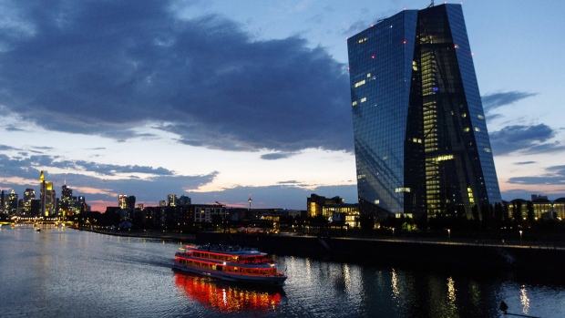 A sightseeing boat travels on the River Main past the European Central Bank (ECB) skyscraper headquarters, right, at dusk in Frankfurt. 