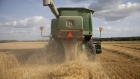 A worker operates a Deere & Co. John Deere brand combine harvester during a wheat harvest at a farm in Kirkland, Illinois, U.S., on Monday, July 15, 2019. A heat wave through most of the U.S. is expected to be supportive for grains futures at a time when an already-compromised crop due to an overly-wet planting season is in a fragile state. 
