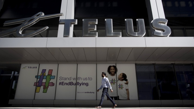 A pedestrian walks past the Telus Harbour building in Toronto, Ontario, Canada, on Monday, July 9, 2018. Telus Corp. shares rose 1.6 percent, more than any full-day gain since Feb. 21 and more than double Canada's benchmark index. 