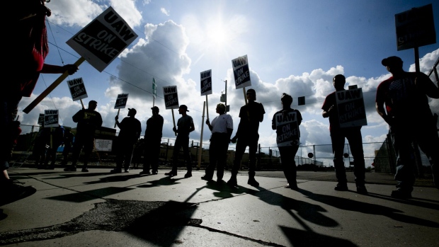 Demonstrators hold signs during a United Auto Workers strike outside the General Motors plant in Flint, Michigan on Sept. 16, 2019. 