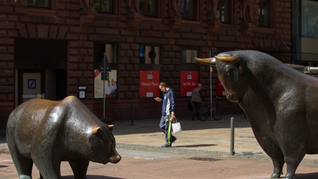 A pedestrian walks past a bear and a bull statue outside the Frankfurt Stock Exchange in Frankfurt, Germany, on Monday, July 4, 2016. London Stock Exchange Group Plc shareholders approved Deutsche Boerse AG's acquisition of the 300-year-old exchange Monday in a near-unanimous vote. 
