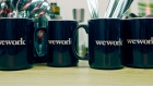 Cutlery stands in WeWork Cos. branded mugs in a kitchen area in the WeWork Cos. co-working space at the One Poultry building in the City of London, U.K., on Wednesday, Oct. 3, 2018. Hana Financial Group Inc. is in talks to buy the building, best known for its stripes of pink and yellow limestone, that has been transformed into a major WeWork Cos. co-working space. 