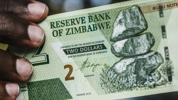 A man holds a Zimbabwean two dollar bond banknote for an arranged photograph in Harare, Zimbabwe, on Tuesday, July 31, 2018. Zimbabwe's main opposition party said it was well ahead in the first election of the post-Robert Mugabe era and it's ready to form the next government, as unofficial results began streaming in. 