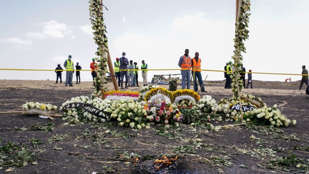 Candles burn before a flower adorned memorial arch erected at the site of the Ethiopian Airlines Flight ET302 crash on March 14, 2019 in Ejere, Ethiopia. 