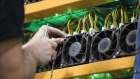 An employee changes the fan on a mining machine at the Bitfarms cryptocurrency farming facility in Farnham, Quebec, Canada, on Wednesday, Jan. 24, 2018. Bitfarms says it's making more than $250,000 a day from minting Bitcoin, other virtual currencies and fees at four sites in the province. 