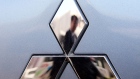 JAPAN - MARCH 11: A man is reflected in the Mitsubishi Motors Corp. logo at the company's headquarters in Tokyo, Japan, on Tuesday, March 11, 2008. 
