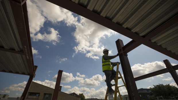 A construction worker uses a ladder to check a reinforced steel joist (RSJ) on a residential site in the Tower Hamlets district of London, U.K., on Monday, July 29, 2019. High living costs and a falling pound are further deterrents for EU citizens considering settling in Britain. 
