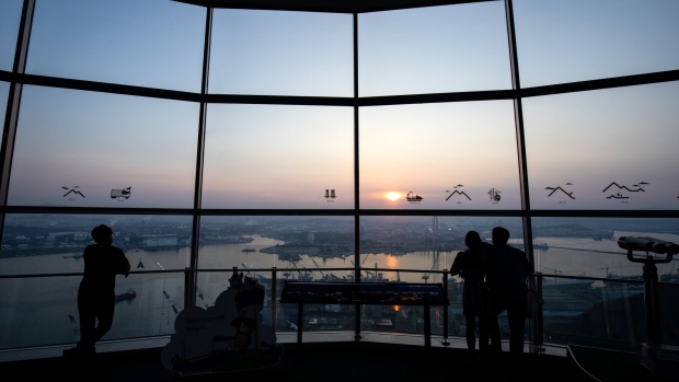 Visitors are silhouetted as they look out at the city skyline from the Ulsan Bridge Observatory in Ulsan, South Korea, on Sunday, Aug. 4, 2019. Ulsan is known as Hyundai Town, an industrial powerhouse with the world’s largest car-assembly plant, its third-biggest oil refinery and the giant shipyards. Since 2016, some 35,000 workers quit or lost their jobs at the city's shipyard, in a downturn as dramatic as it was sudden. 