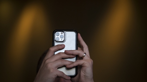 An attendee uses an iPhone 11 Pro smartphone to take a photograph during TechCrunch Disrupt 2019