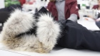 An employee checks a finished jacket with a fur collar at the new Canada Goose Inc. manufacturing fa