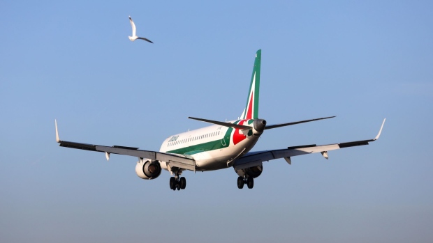 A bird flies past an Embraer passenger aircraft, operated by Alitalia SpA, as it prepares to land at London City Airport in London, U.K., on Thursday, Jan. 5, 2017. Alitalia shareholders approved Etihad Airways PJSC investment of up to $231m, Etihad became Alitalia's largest shareholder in 2014 as part of the Persian Gulf carrier's attempt to gain a European foothold by strengthening struggling carriers in the region. 