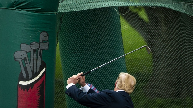 U.S. President Donald Trump swings a golf club during the White House Sports and Fitness Day event o