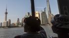Passengers look out at the skyscrapers of the Pudong Lujiazui Financial District while taking a ferry across the Huangpu River in Shanghai, China, on Monday, July 29, 2019. Chinese trade negotiators will host their U.S. counterparts at a landmark of jazz-era Shanghai on the city's riverside Bund, re-opening trade talks with a marked change of atmosphere after an almost three-month hiatus. 