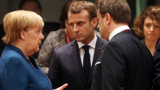 Angela Merkel, Germany's chancellor, left, speaks with Emmauel Macron, France's president, center and Xavier Bettel, Luxembourg's prime minister, ahead of round table talks at a European Union (EU) leaders summit in Brussels, Belgium, on Friday, Oct. 18, 2019. Prime Minister Boris Johnson's Brexit deal with the European Union was barely agreed before it ran into trouble at home, as his Northern Irish allies in parliament said they could not support it. 